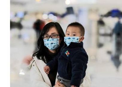 سيدة وطفلها يرتديان الكمامة خوفا من فيروس كورونا