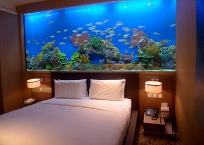 حوض سمك كبير خلف السرير