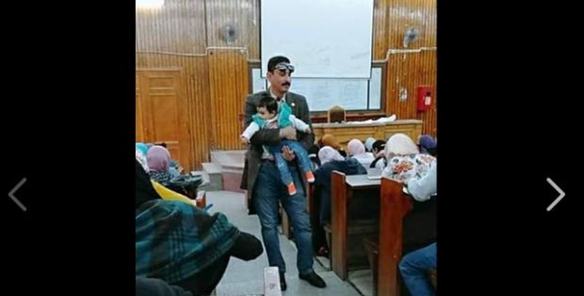 الأستاذ الجامعي يحمل الرضيعة