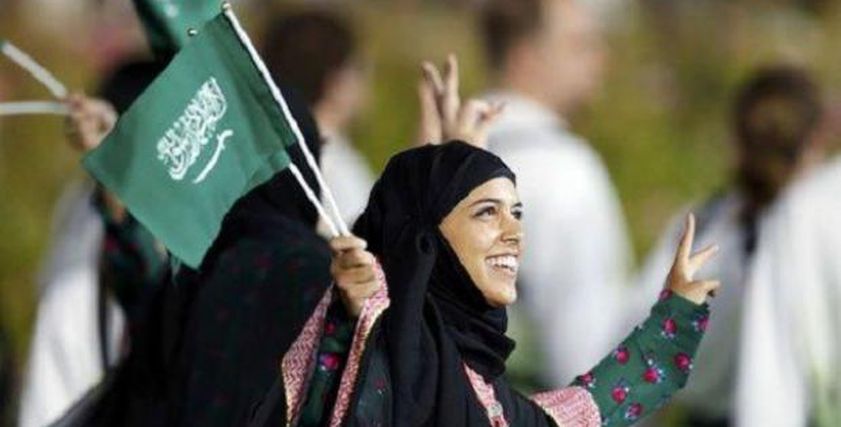 سيدات السعودية يرفع علم المملكة العربية السعودية
