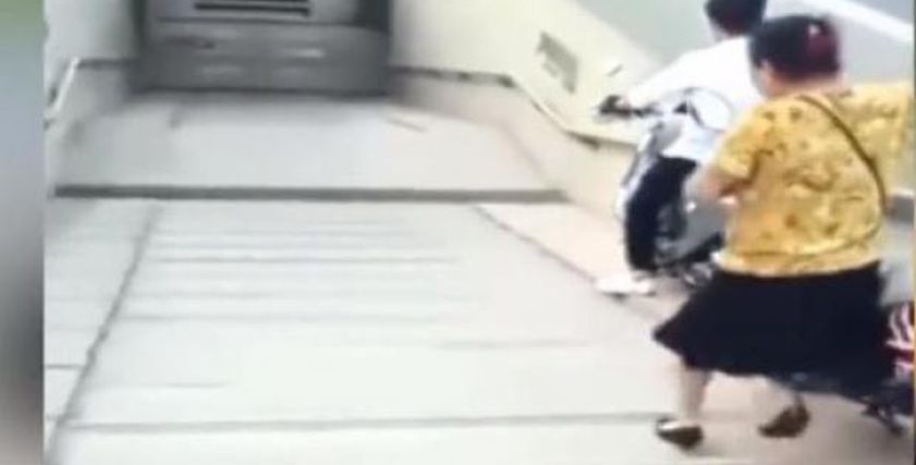 مرأة تسقط على الأرض بعد نزول دراجتها من فوق السلم 