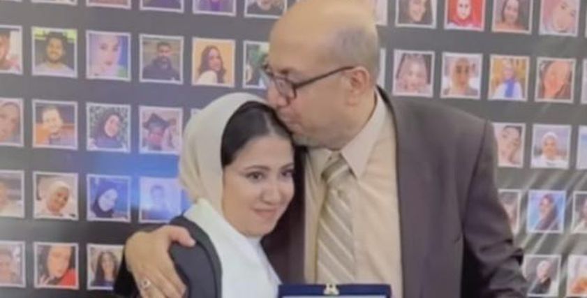 طالبة تهدي والدها درعا في حفل تخرجها