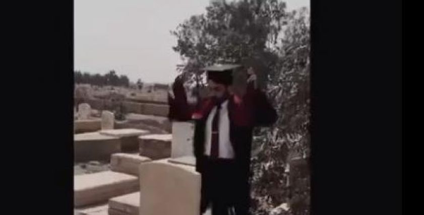 شاب يحتفل بتخرجه عند قبر أمه