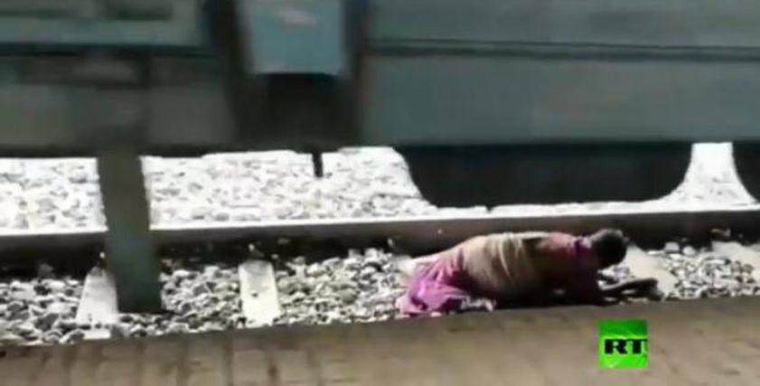 بالفيديو ..عجوز هندية تستلقى بين عجلات القطار أثناء عبور القضبان