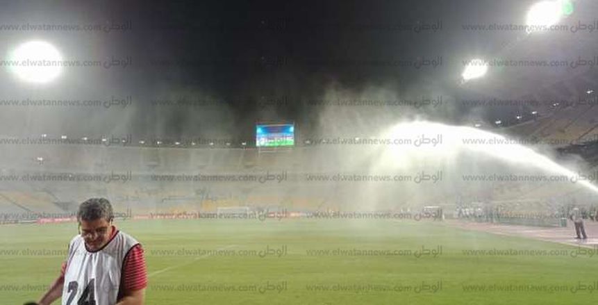 بالصور| رش أرضية ملعب "برج العرب" بطلب من الجهاز الفني للأهلي