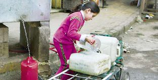 طفلة سورية تجلب المياه لأسرتها فى مدينة «حلب» «أ. ف. ب»