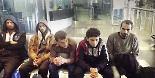 عدد من الشباب العائدين لدى وصولهم مطار القاهرة أمس