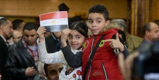 طفلان يرفعان علم مصر خلال انعقاد جلسة الحكم