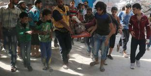 رجال الإسعاف والأهالى أثناء محاولة إسعاف أحد المصابين فى القصف الجوى بمدينة حلب