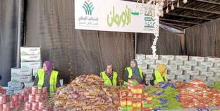 متطوعو «كتف في كتف» أثناء إعداد المواد الغذائية فى محافظة الفيوم لتوزيعها على الأكثر احتياجاً