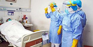 أطباء صينيون خلال معاينتهم لمصاب بفيروس كورونا