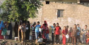 أطفال وسيدات قرى بنى سويف أثناء تعبئة الجراكن بمياه الطلمبات المجاورة للمصارف الزراعية