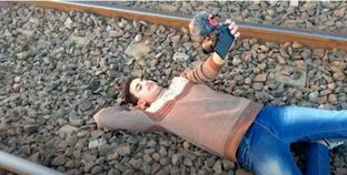 لقطة من الفيديو أثناء نوم شاب على أحد قضبان السكة الحديد