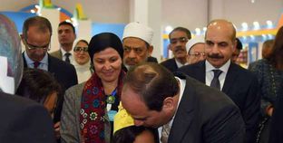 الرئيس يقبل رأس الطفلة «سما» خلال افتتاح المعرض أمس الأول