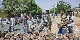 عدد من المتظاهرين يبنون المتاريس خلال اعتصامهم أمام قيادة الجيش السودانى «أ.ف.ب»