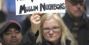 مواطنة أمريكية تحتج على قرارات «ترامب» بلافتة «نحب جيراننا المسلمين» «أ. ف. ب»