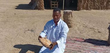 منصور سعيد من سكان جنوب البحر الأحمر يحمل خبز القبوري