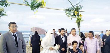 العروسان مع المصطافين على الشاطئ