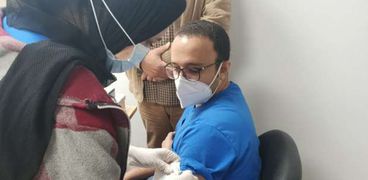 الدكتور محمد طالب مدير مستشفى عزل النجيلة خلال تلقيه لقاح كورونا