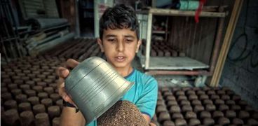 الطفل الفلسطيني نادر قشطة أثناء تصنيع القوالب