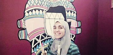 «مى» أمام أحد رسوماتها على الجدران