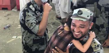 رجل أمن سعودي يحمل طفلة