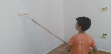 «عبدالرحمن» يقوم بدهان أحد الجدران