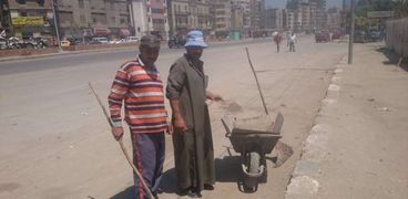 العاملان ينظفان الشارع