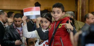 طفلان يرفعان علم مصر خلال انعقاد جلسة الحكم