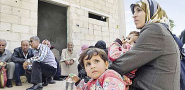 عدد من الأسر السورية بعد إجلائهم من المناطق التى يسيطر عليها «داعش» فى «إدلب» «أ.ف.ب»