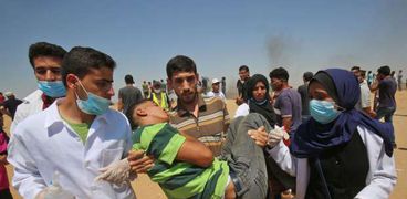 مسعفون ينقلون أحد الجرحى فى اشتباكات مع جيش الاحتلال
