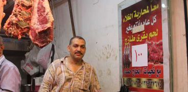 «حمدى» أمام لافتة محاربة ارتفاع الأسعار