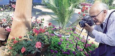 «فريد» يلتقط إحدى صوره فى معرض الزهور بالأورمان