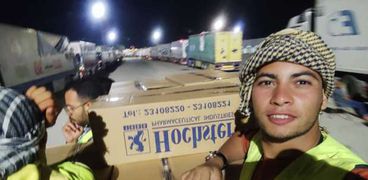 عمرو أمام شاحنة مساعدات في معبر رفح