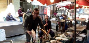 «مصطفى» ينتظر زبائن الأسماك فى سوق الميدان بالإسكندرية