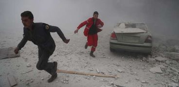 أفراد من «الصليب الأحمر» يفرون من غارات طائرات النظام السورى «أ. ف. ب»