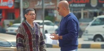 الإعلامي أيمن مصطفى مع موظف الأمن ببرنامج «حياة كريمة»