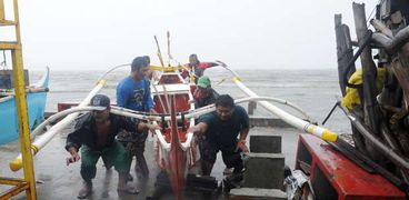 بالصور| صيادو الفلبين ينقذون مراكبهم من إعصار "كوبو"