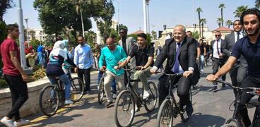 رئيس جامعة القاهرة يقود دراجة وسط الطلاب