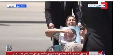 سيدة عجوز تحمل صورة الرئيس عبدالفتاح السيسي