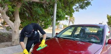 أحد الشباب أثناء قيامه بتنظيف السيارة