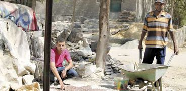 حمادة عبدالرحمن أحد عمال الزلط يقضى النهار فى رص الزلط ولصقه