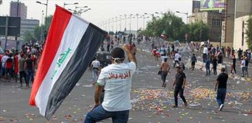 متظاهر يحمل علم العراق