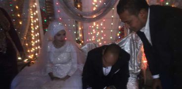 بالصور| عروسان بقنا يوقعان على استمارة "عشان تبنيها"