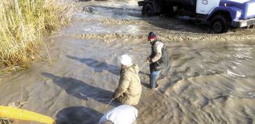 العمال الثلاثة يحاولون سحب المياه من الكيلو 21 بالإسكندرية