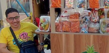 شريف أشرف في أثناء بيعه أطباق الفاكهة