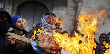 فلسطينيون بالضفة الغربية يحرقون «دمية ترامب»