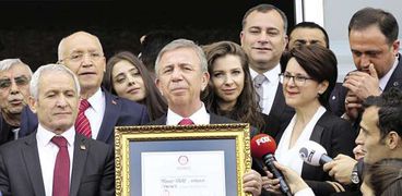 رئيس بلدية «أنقرة» المعارض لأردوغان يحمل وثيقة فوزه «أ.ف.ب»
