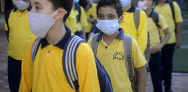 تلاميذ المدارس يلتزمون بارتداء الكمامات الطبية أثناء دخول المدارس بالفصل الدراسي الاول