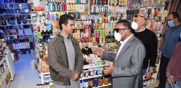 محافظ مطروح خلال الحديث مع احد التجار للاطمئنان على سوق ليبيا